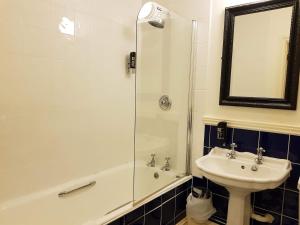 a bathroom with a shower and a sink and a tub at Episode Hotel in Leamington Spa