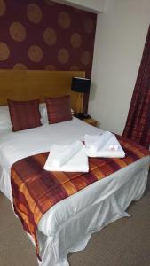 a bed with two white towels on top of it at Episode Hotel in Leamington Spa