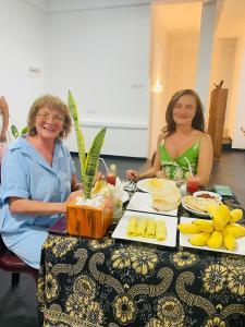 two women sitting at a table with food on it at Double T in Dickwella
