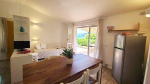 a kitchen with a wooden table and a refrigerator at Residence Capobianco in Portoferraio
