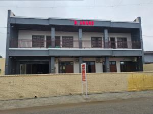 a building with a red sign on top of it at Hotel B Anand in Aonla