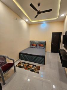 a bedroom with a bed and a ceiling fan at Hotel B Anand in Aonla