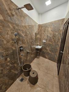 a bathroom with a shower and a sink at Hotel B Anand in Aonla