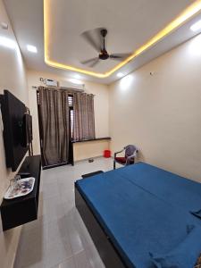 a bedroom with a blue bed and a ceiling fan at Hotel B Anand in Aonla +17 photos