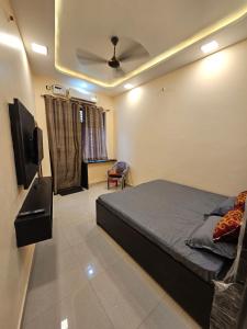 a bedroom with a bed and a ceiling fan at Hotel B Anand in Aonla