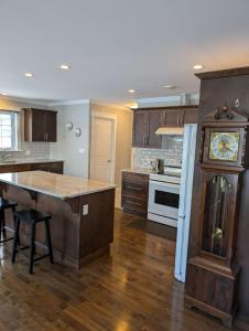 a large kitchen with a clock in the middle of it at Birch Woods House in Stratford