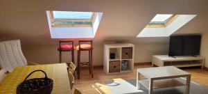 a living room with two skylights and two stools at Atico en Carnota para 4 personas in Vilar
