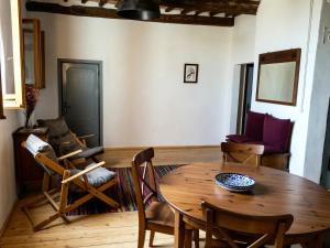 a living room with a wooden table and chairs at La Salvia in Scansano