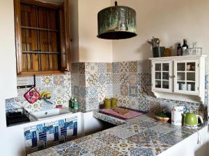 a kitchen with tiles on the wall and a counter at La Salvia in Scansano