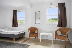 a bedroom with a bed and two chairs and a table at Hillesgården in Boarp