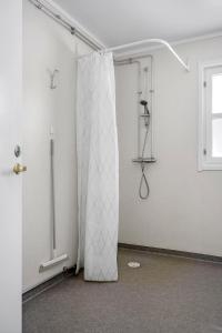 a bathroom with a shower curtain in a room at Hillesgården in Boarp
