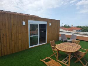 a patio with a table and chairs on the grass at Cantinho nas Varzeas in Loulé
