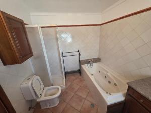 a bathroom with a toilet and a bath tub at Cantinho nas Varzeas in Loulé +8 photos