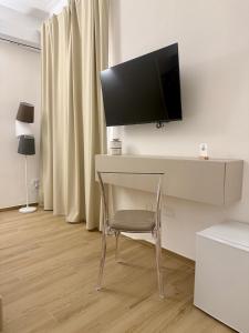 a desk with a chair and a tv on a wall at Gegè Relais in San Corrado di Fuori