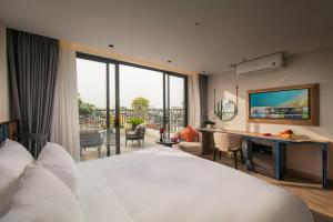 a hotel room with a bed and a desk with a view at MAY DE VILLE Prestige Hotel in Hanoi
