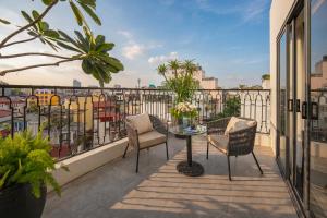 a balcony with a table and chairs and a view at MAY DE VILLE Prestige Hotel in Hanoi
