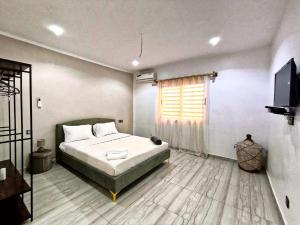 a bedroom with a bed and a flat screen tv at Luxe villa 3 chambres Somone in Somone