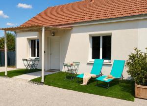 a house with two chairs and a table in the yard at Le temps de la pause 2 in Cepoy
