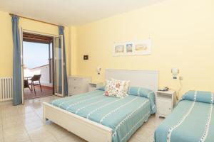 a bedroom with two beds and a desk at Hotel Ape Regina in Ischia