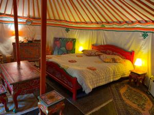 a bedroom with a canopy bed with two tables at Bastide de montchamp in Malataverne