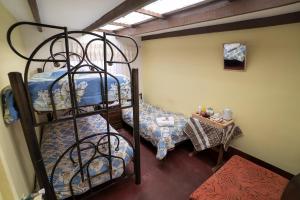 a room with a bunk bed and a table with a tableasonable at Hostal Terra Sal - Bed, Breakfast, Garage & Salar de Uyuni Tours in Uyuni