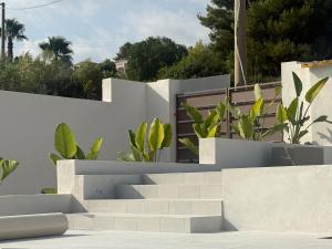 a white house with stairs and plants at Gegè Relais in San Corrado di Fuori