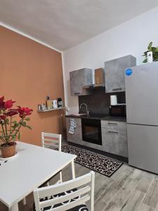 a kitchen with a white table and a refrigerator at Isabel House in Capoterra +24 photos