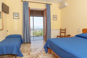 a bedroom with two beds and a balcony at Hotel Ape Regina in Ischia