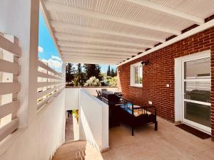 a patio with a white pergola and a desk at The Blue House in Larnaca