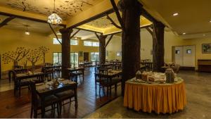 a restaurant with tables and chairs in a room at Indo Asia Heritage, Madikeri, formerly Hotel Coorg International in Madikeri