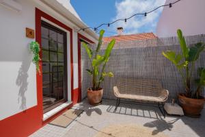 a patio with a bench and plants and a wall at Brisa de Milfontes in Vila Nova de Milfontes