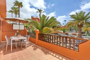 a balcony with a table and chairs and palm trees at Oasis Royal in Corralejo