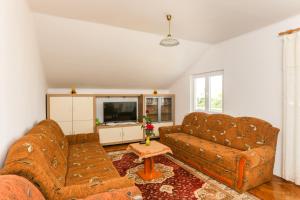 Una sala de estar con dos sofás y un televisor. en Apartments Nada, en Cavtat
