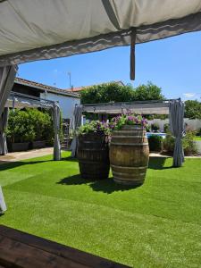 a patio with two large barrels filled with flowers at Lila Natur León1 Apartment 4 Pers in Villafañé
