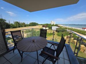 a balcony with a table and chairs and an umbrella at Fehmarn- Ostseeferien FeWo Prusseit 171 in Fehmarn
