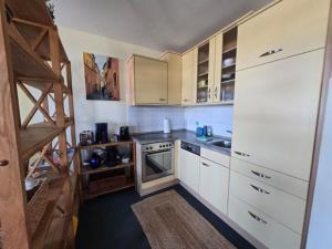 a small kitchen with white cabinets and a stove at Fehmarn- Ostseeferien FeWo Prusseit 171 in Fehmarn +6 photos