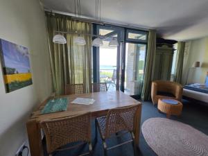 a dining room with a table and chairs with a view at Fehmarn- Ostseeferien FeWo Prusseit 171 in Fehmarn