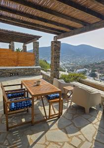 a table and chairs on a patio with a view at Panostria Apartments Sifnos in Sifnos +7 photos