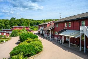 a row of red buildings on a dirt road at Hillesgården in Boarp