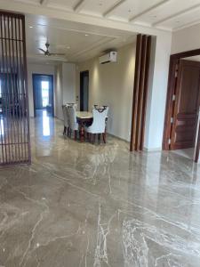 a dining room with a table and chairs on a marble floor at Luxury Executive Homestay in Jāmb +2 photos