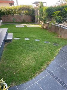 a small yard with a bench and a grassy area at Luxury Executive Homestay in Jāmb