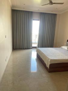 a bedroom with a bed and a large window at Luxury Executive Homestay in Jāmb