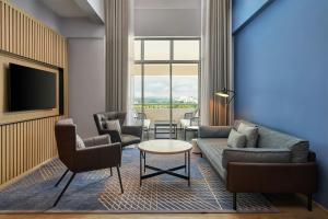 a living room with a couch and chairs and a tv at Four Points by Sheraton Johor Bahru in Kampong Telok Jawa