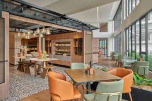 a dining room with tables and chairs and windows at Four Points by Sheraton Johor Bahru in Kampong Telok Jawa
