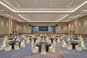 a conference room with tables and chairs and a screen at Four Points by Sheraton Johor Bahru in Kampong Telok Jawa +37 photos