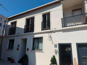 a white house with black balconies on a street at Go to Sleep in Gelibolu
