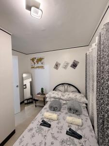 ein Schlafzimmer mit einem großen Bett in einem Zimmer in der Unterkunft Sakura Crib at Xevera Calapan in Camilmil