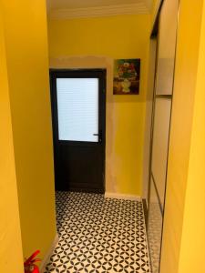 a hallway with a black door and a tile floor at Go to Sleep in Gelibolu +1 photo