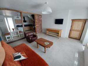 a living room with a couch and a table at Le sabot de Madame in Lussac-les-Châteaux