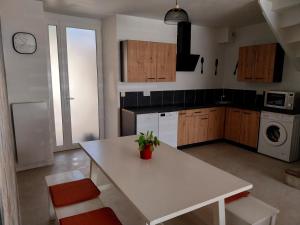 a kitchen with a white table and a sink at Le sabot de Madame in Lussac-les-Châteaux